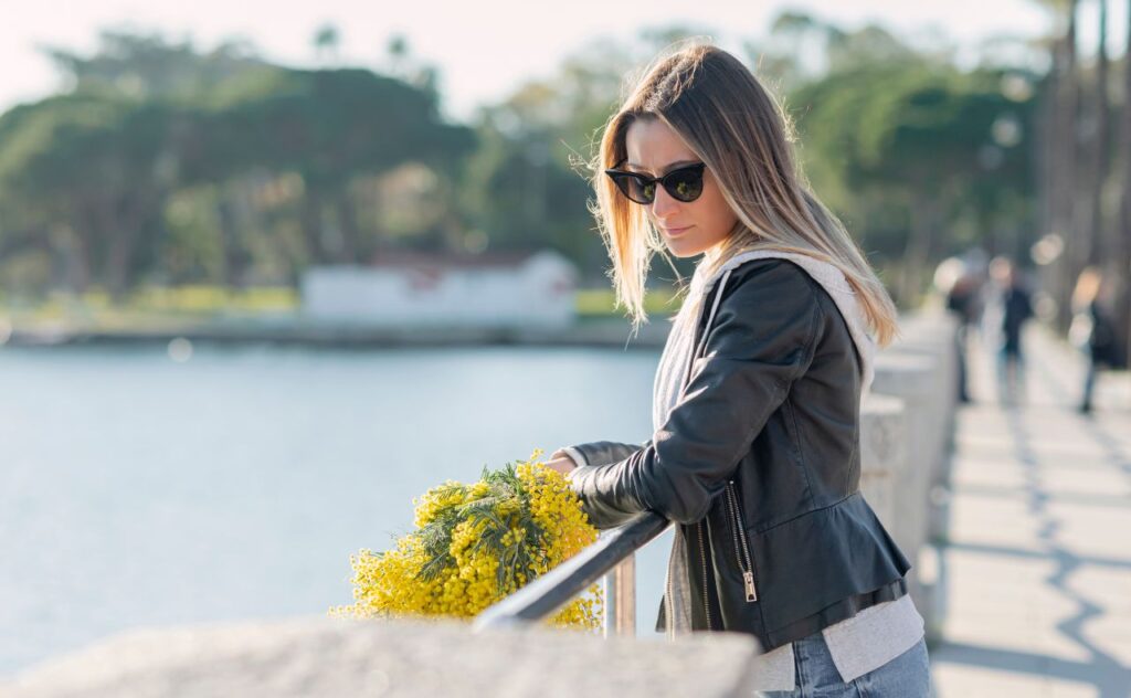 When Mother's Day is hard. Woman looking sad while holding yellow flowers.