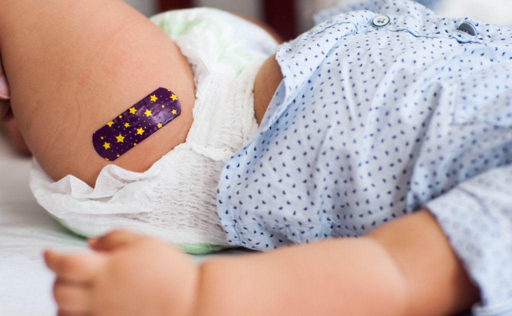 baby boy with medical plaster after vaccination. Immunisation day checklist