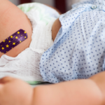 baby boy with medical plaster after vaccination. Immunisation day checklist